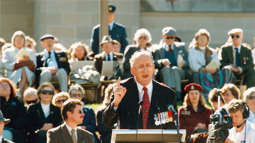 a man stands at a lectern and is giving a speech