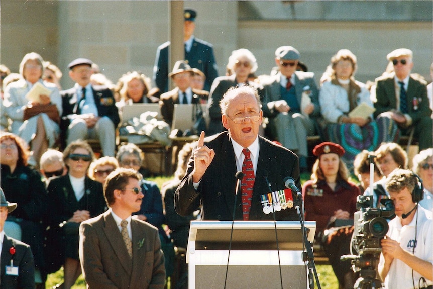 a man stands at a lectern and is giving a speech