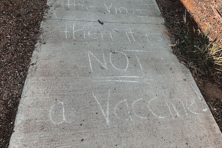 An anti COVID-19 vaccine message written in white chalk on a footpath in Tara, Queensland, December 2022.