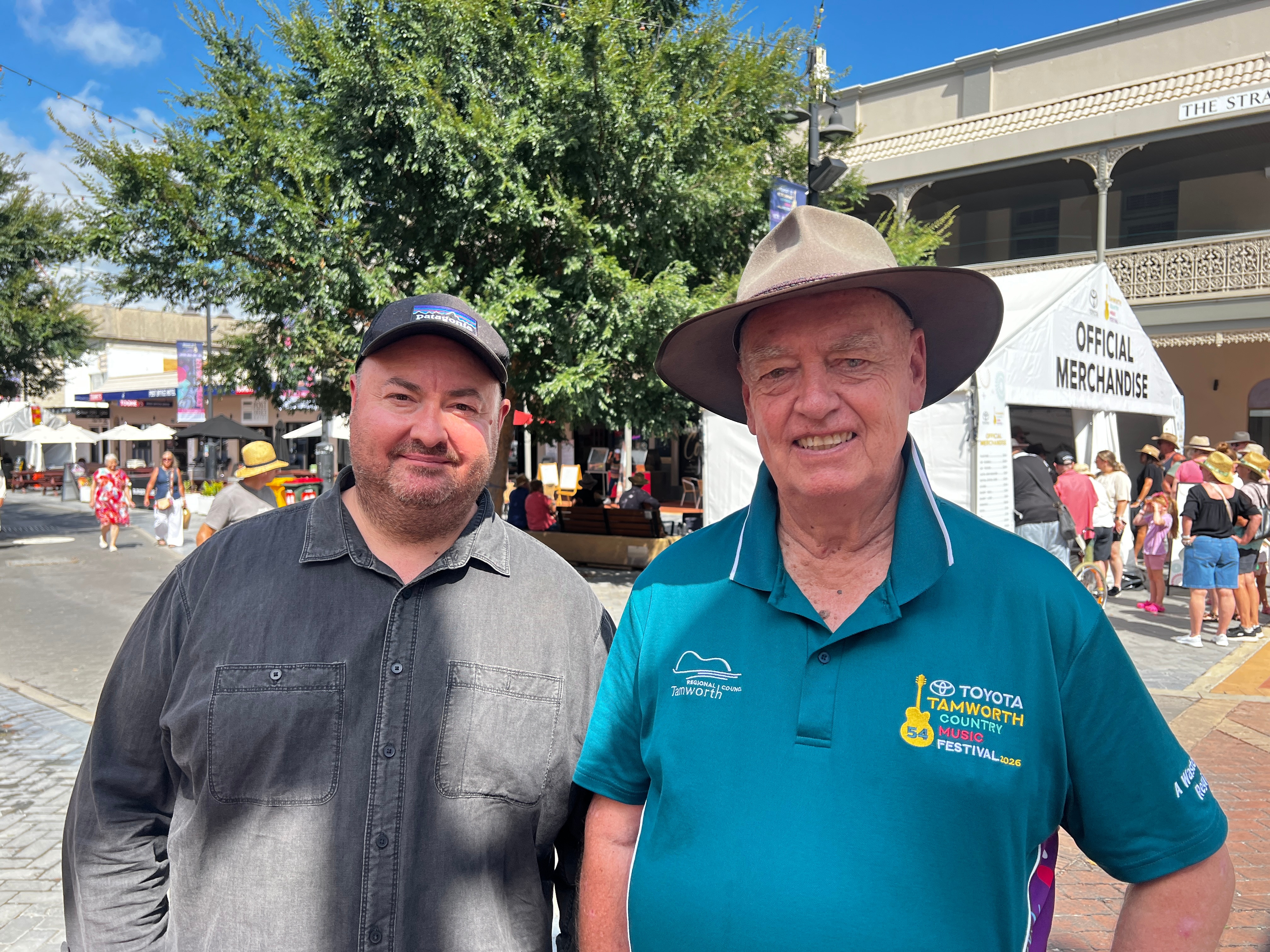 dois homens sorriem para a câmera