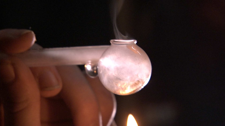 Video still - someone smoking a crystal meth pipe, October 2014.