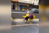 An image taken from video showing a woman sitting on a bench outside a bubble tea shop in the Melbourne suburb of Carnegie.