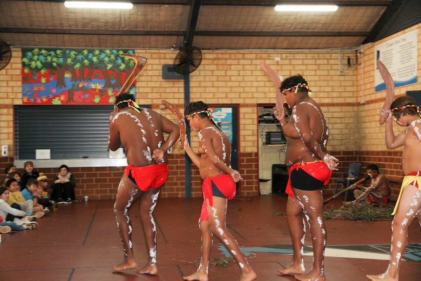 Four Ngadju dancers performing at a school.