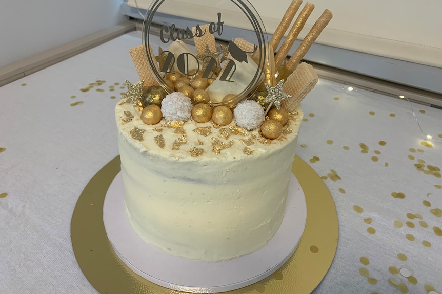 white cake with gold trimming and 'class of 2022' detail 