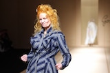Vivenne Westwood with orange curly hair, wearing her own blue and grey striped dress, at end of runway, 2007 Paris Fashion Week
