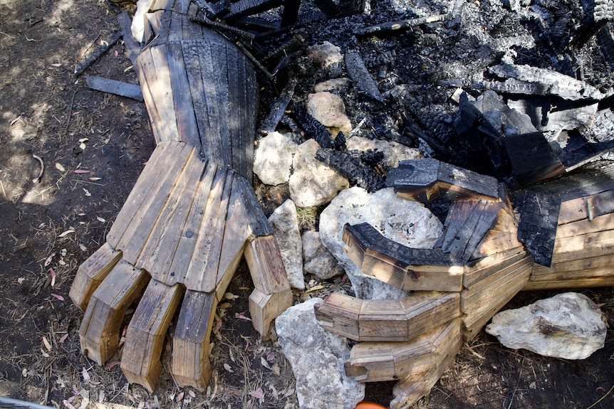 Charred wooden hands from a sculpture of a giant figure.