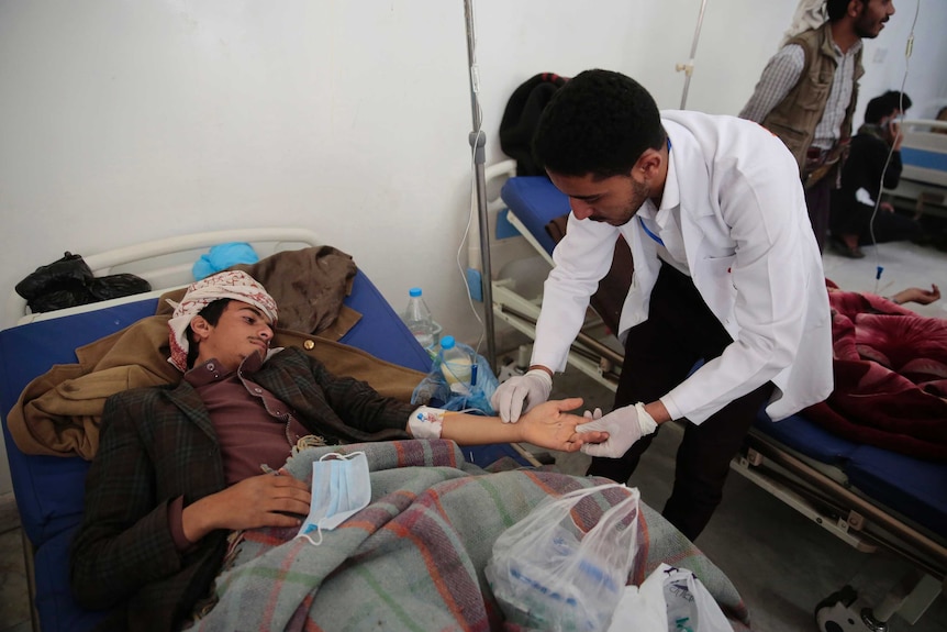 A man lying in a hospital is treated for suspected cholera infection at a hospital in Sanaa, Yemen