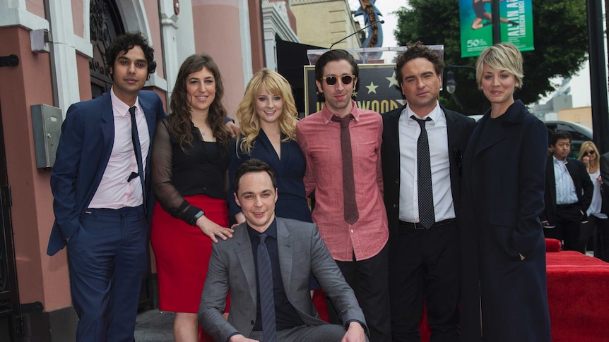 Jim Parsons crouches with his Hollywood Walk of Fame star