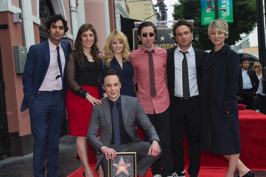 Jim Parsons crouches with his Hollywood Walk of Fame star