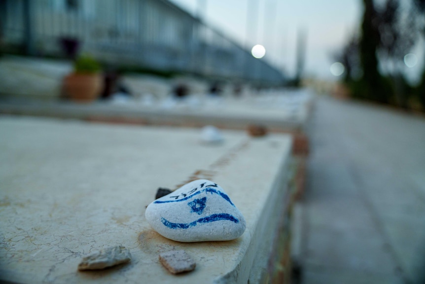 A rock with the Israel flag painted on it.