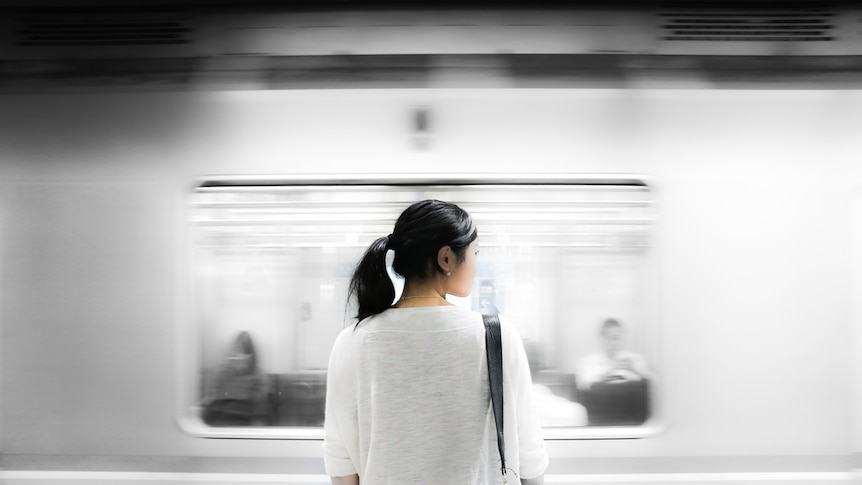 A woman waits for a train.