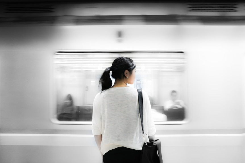 A woman waits for a train.