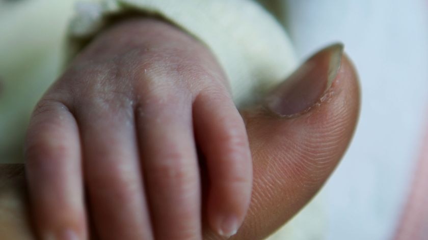 Newborn clings to dad