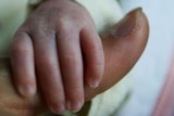 Newborn clings to thumb