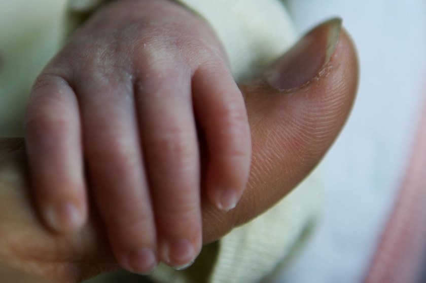 Newborn clings to dad