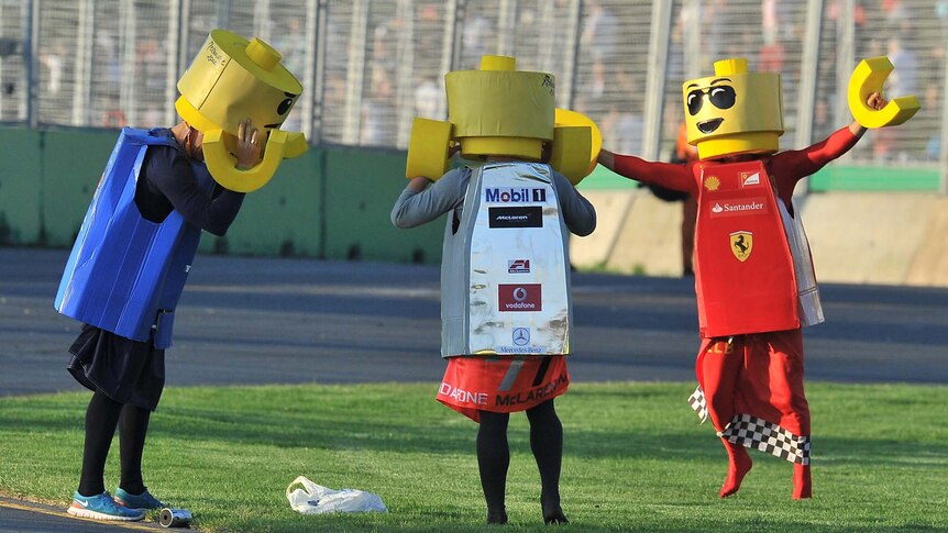 Fans dressed as Lego-men characters dance on the track