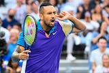 Nick Kyrgios hands his left hand to his ear as he gestures to the crowd.