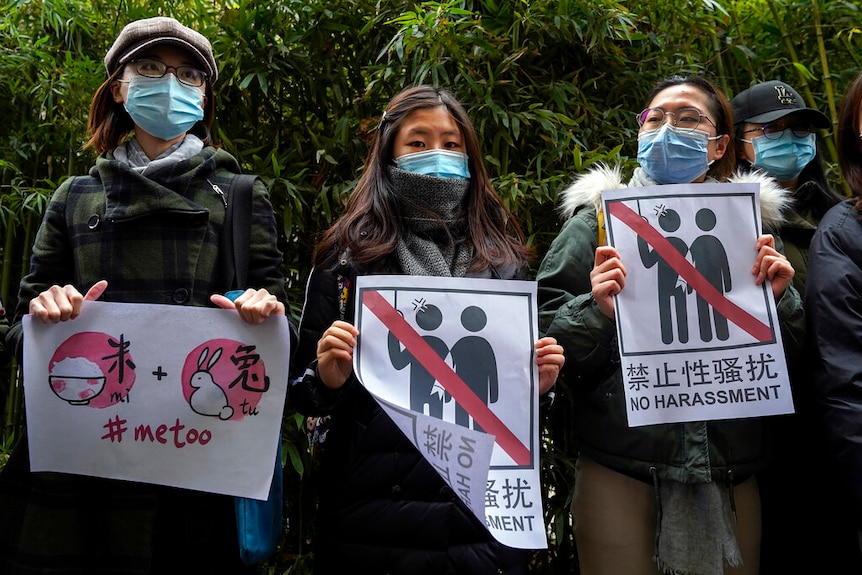 Supporters of Zhou Xiaoxuan hold banners while Zhou's lawsuit against a Chinese TV star was heard