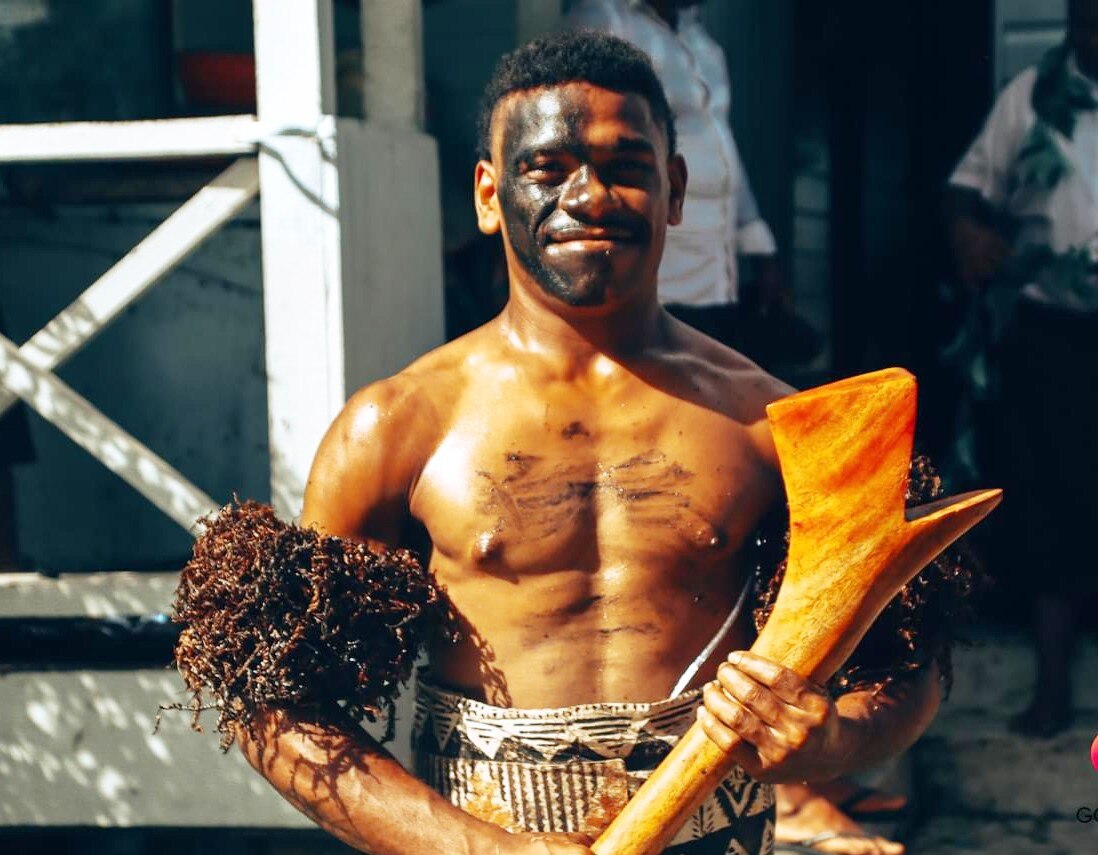 A Fijian chief with a club smiling 