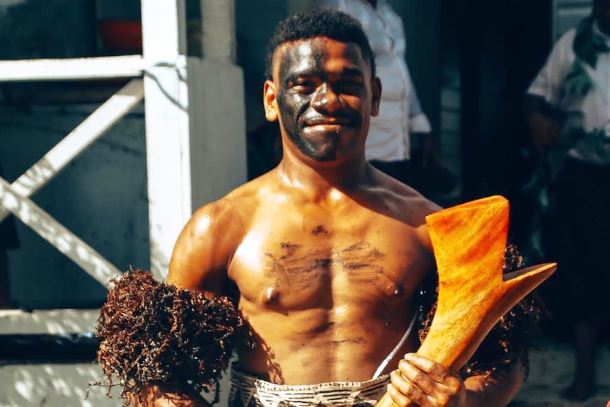 A Fijian chief with a club smiling 