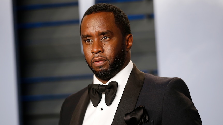 Sean "Diddy" Combs dressed in a suit and bowtie not smiling