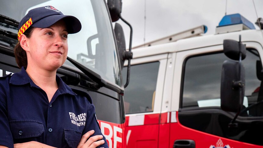 A woman leans against a fire truck