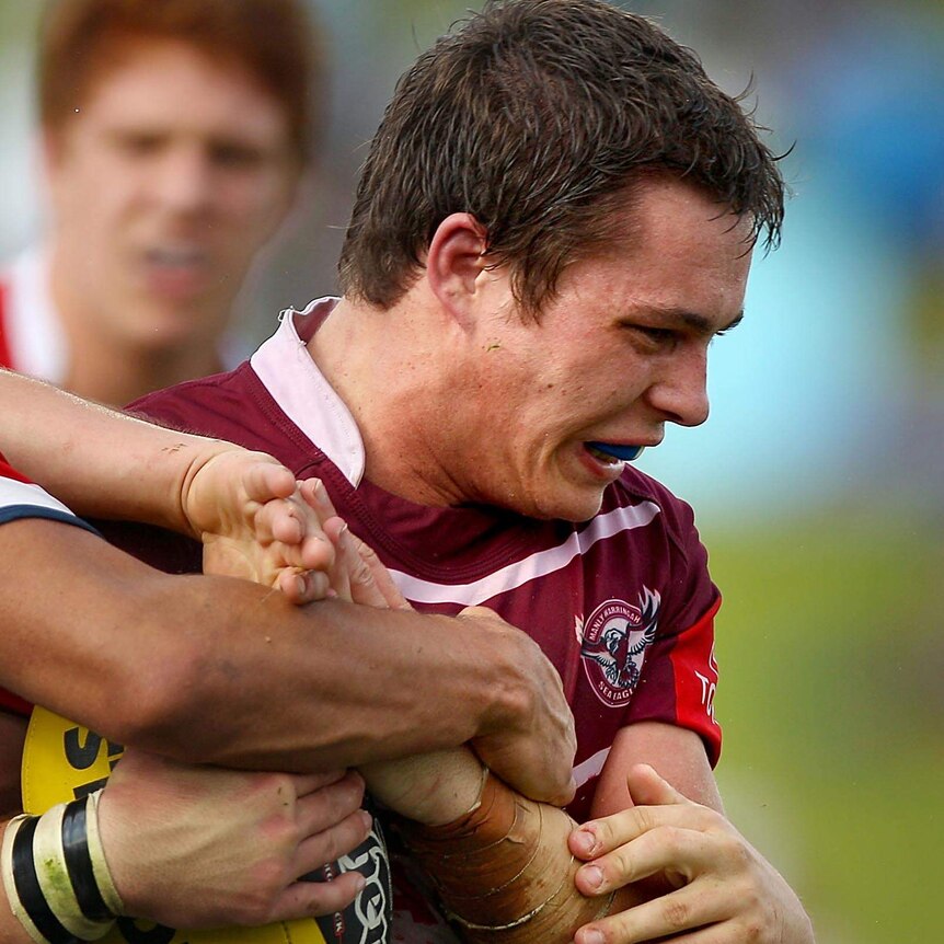 Jason Annear is tackled during a Toyota Cup match.