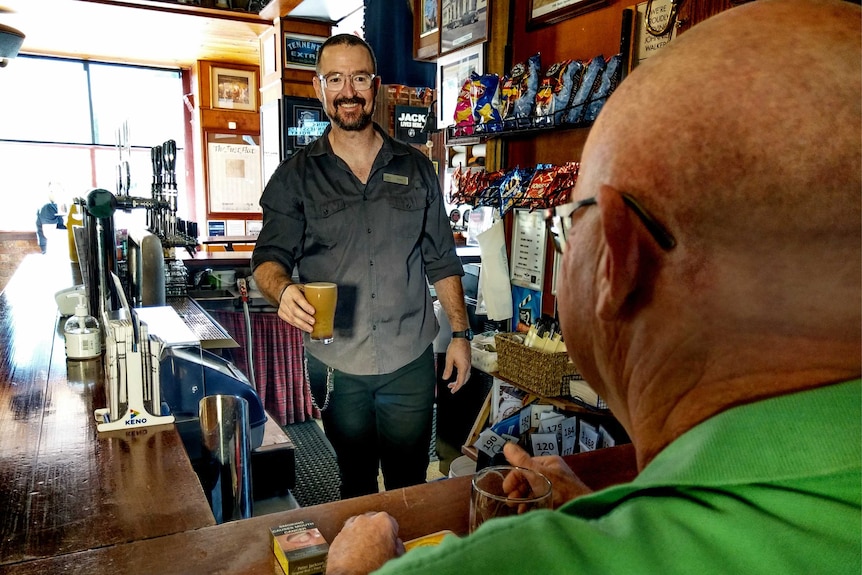 Bartender serves people in the People in the Criterion Hotel in Rockhampton.
