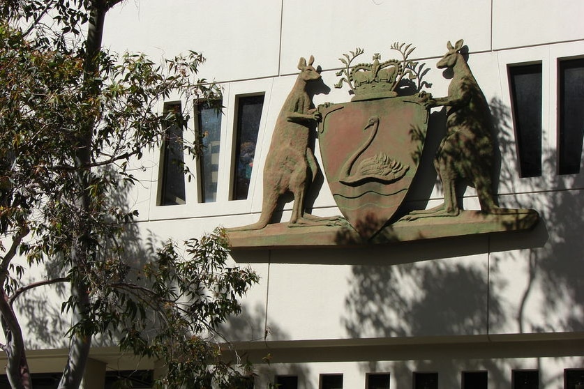 A large crest featuring two kangaroos on the external wall of the Perth Central Law Courts.