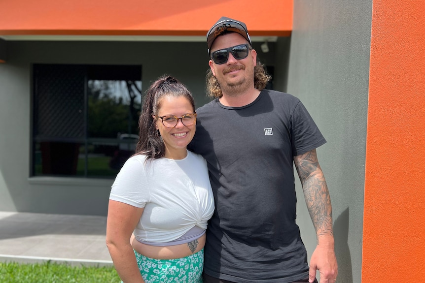 Stacey and Travis stand in front of their house in Mackay. 