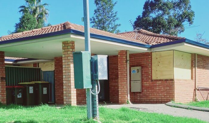 A boarded-up house in a suburban area.