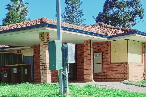 A boarded-up house in a suburban area.