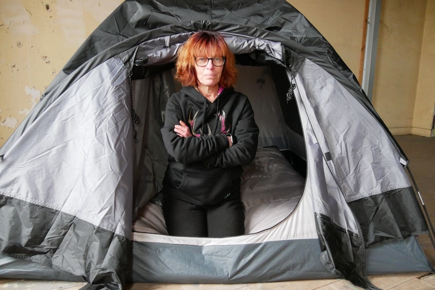 woman with crossed arms sitting in tent