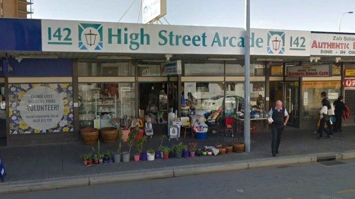 A Google Street View photo of a general store with flowerpots in the front on the verge.