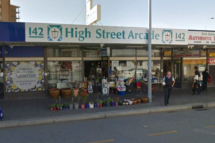 A Google Street View photo of a general store with flowerpots in the front on the verge.