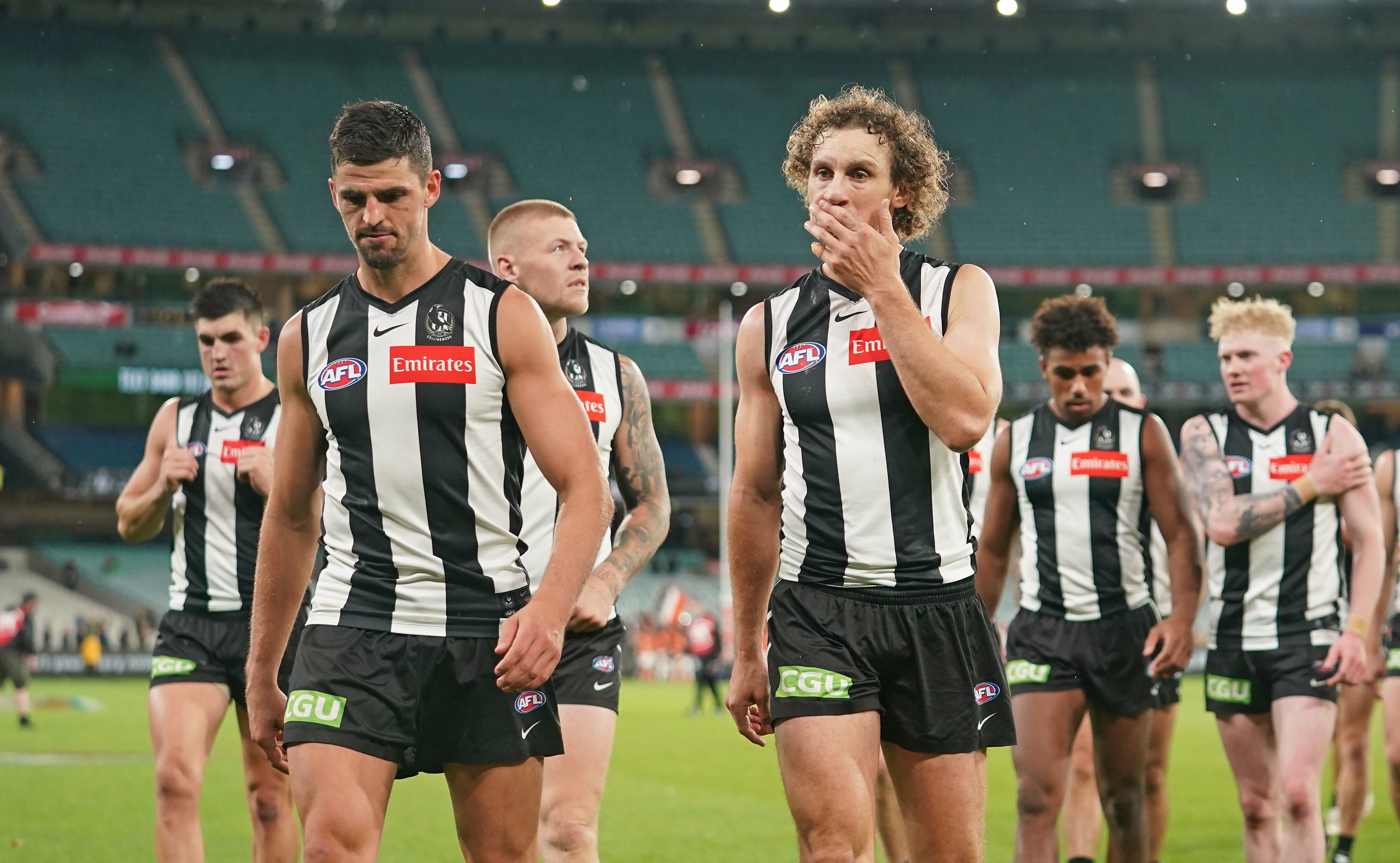 A group of Collingwood AFL players walk off the MCG after a loss to Greater Western Sydney.