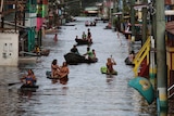 Residents float down the flooded street in boats between houses in Brazil.