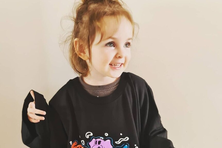 a three year old wearing an oversized triple j Live A Version Wiggles t-shirt