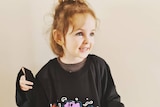 a three year old wearing an oversized triple j Live A Version Wiggles t-shirt