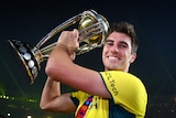 Pat Cummins smiles holding the World Cup trophy