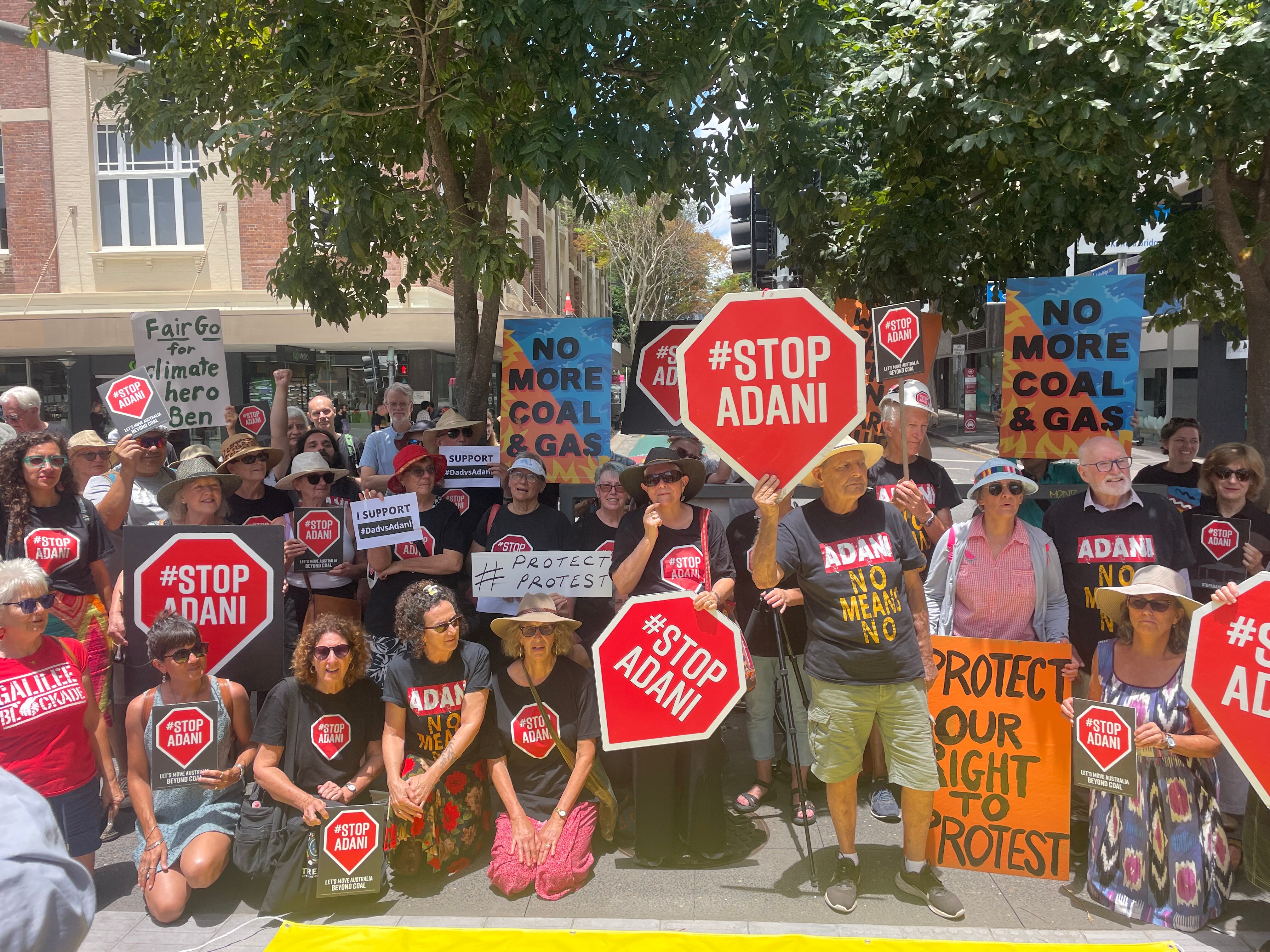 A crowd of people holding signs outside a court house.