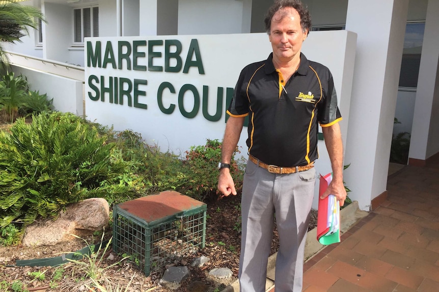 Man stands beside sign for Mareeba Council