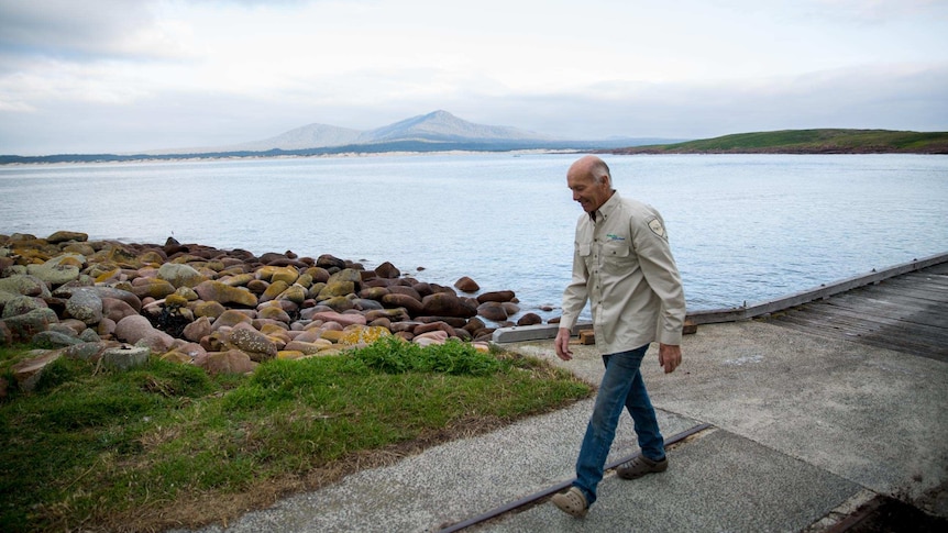 Tony Symes walks from the jetty with the mainland in the background.