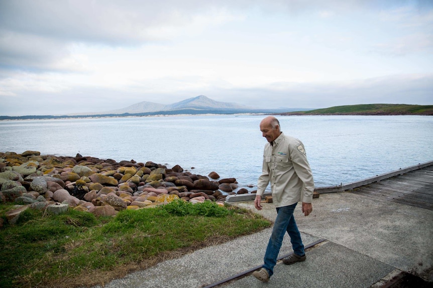 Tony Symes walks from the jetty with the mainland in the background.