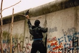 A man chisels into the Berlin Wall in November 1989.