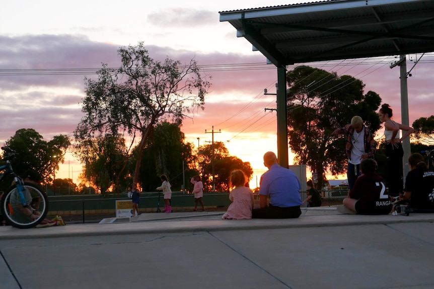 A man and a child watch a sunset at the skate park in Coolgardie. 