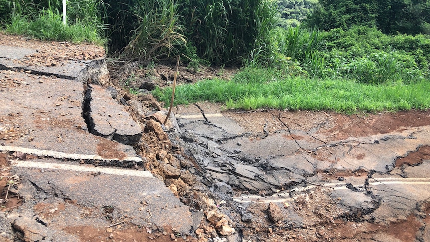 a crumbled road drops down two metres