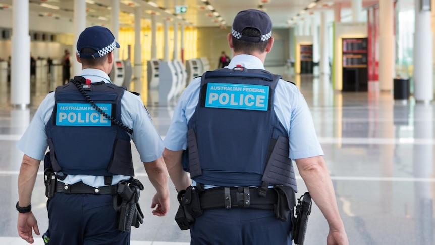 AFP uniformed officers walk through an airport