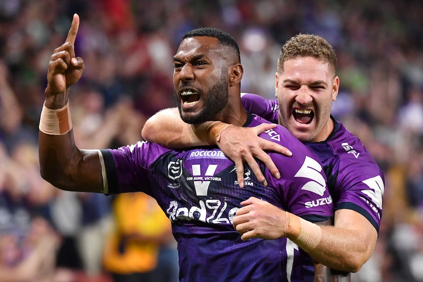 Suliasi Vunivalu is hugged from behind by Brenko Lee during the Melbourne Storm's preliminary final against the Canberra Raiders
