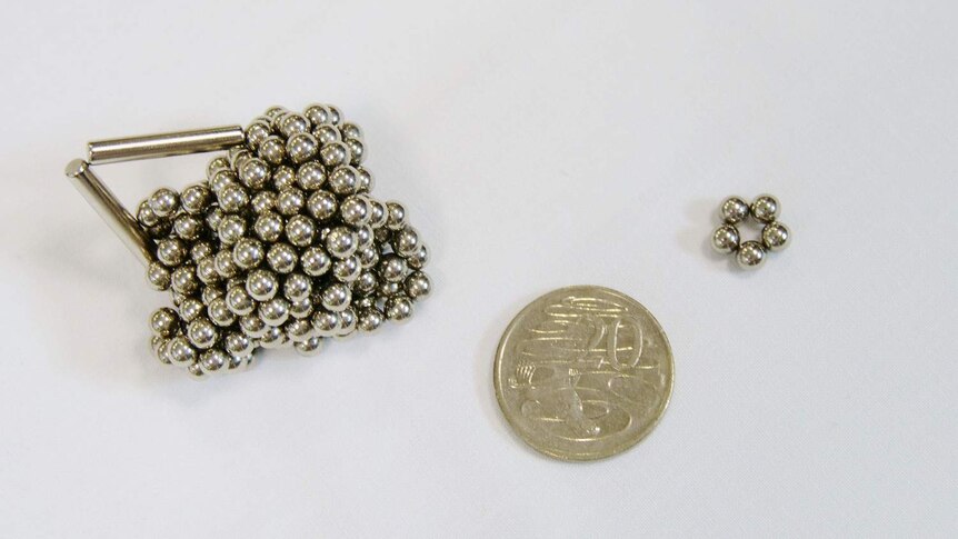 Five magnetic balls next to a 20 cent piece, from a large bundle that were part of a magnetic toy set bought online.